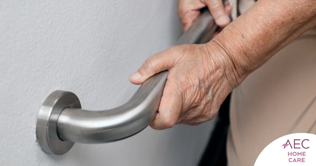 An older adult uses a grab bar representing one of the home modifications that is helpful for fall prevention for elderly adults.